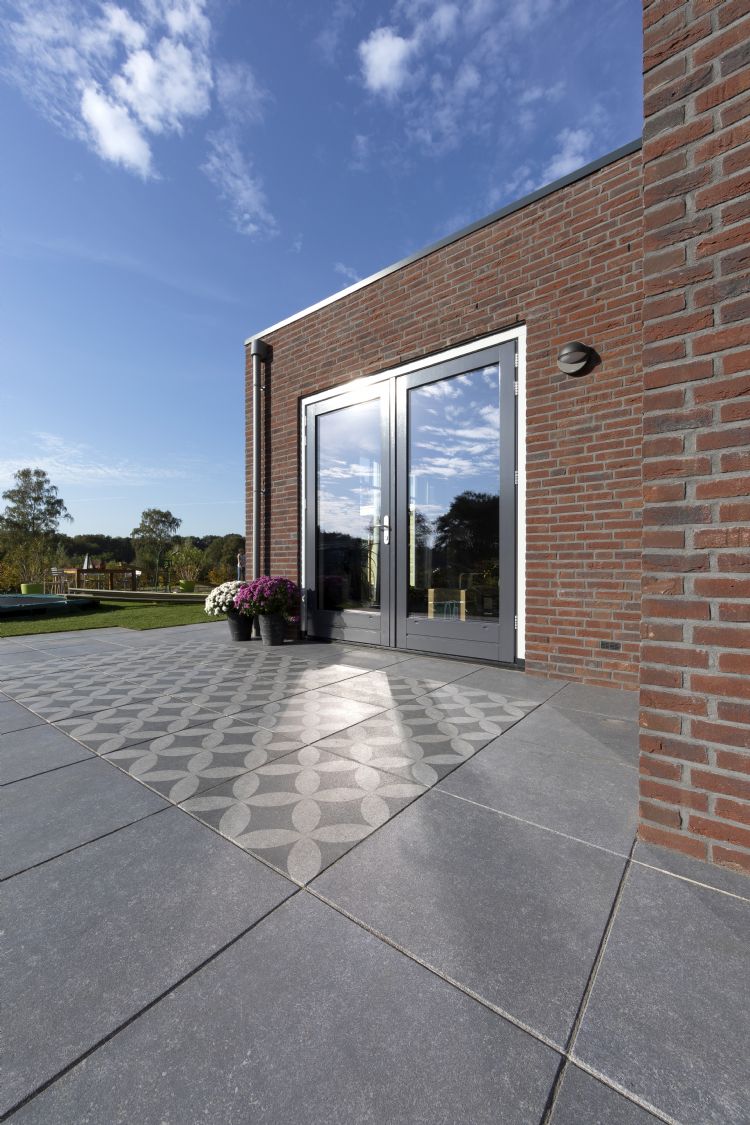 Een nieuw aangelegd terras met Geo Pro Arte-tegels Een nieuw aangelegd terras met Geo Pro Arte-tegels