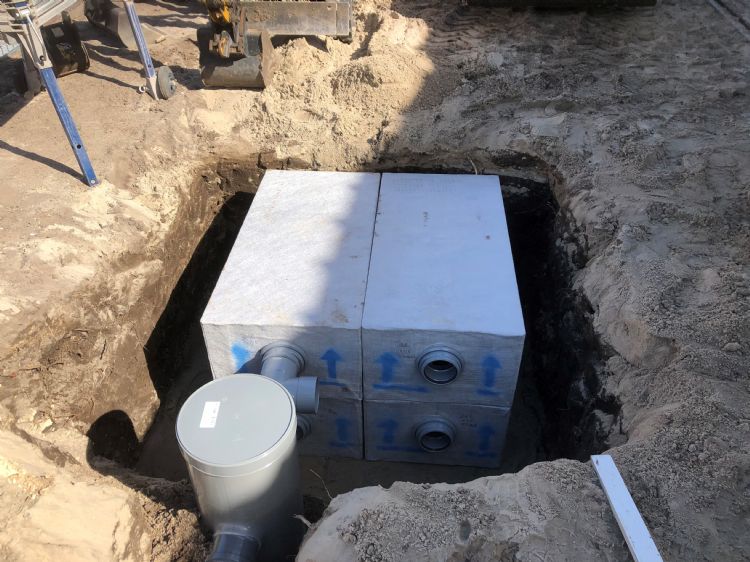 Na het uitgraven van de cunet komt er een laag grof drainagezand om het infiltratiekrat, om een betere verbinding met de ondergrond te krijgen. Na het uitgraven van de cunet komt er een laag grof drainagezand om het infiltratiekrat, om een betere verbinding met de ondergrond te krijgen.