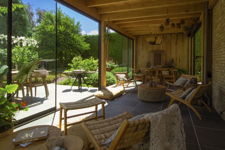 Tuinkamer van eiken met glazenschuifwanden en een authentieke keramische vloer Tuinkamer van eiken met glazenschuifwanden en een authentieke keramische vloer