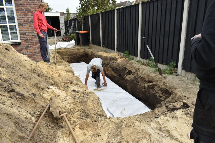 De kratten voor de infiltratiebuffer worden ingepakt met een doek van geotextiel De kratten voor de infiltratiebuffer worden ingepakt met een doek van geotextiel