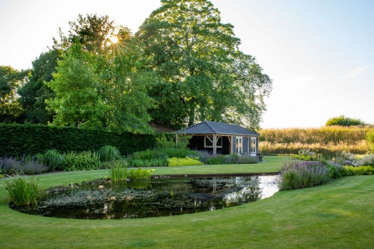 De vijver bestaat voor een deel uit natuurwater van de sloot die achter de tuin ligt De vijver bestaat voor een deel uit natuurwater van de sloot die achter de tuin ligt