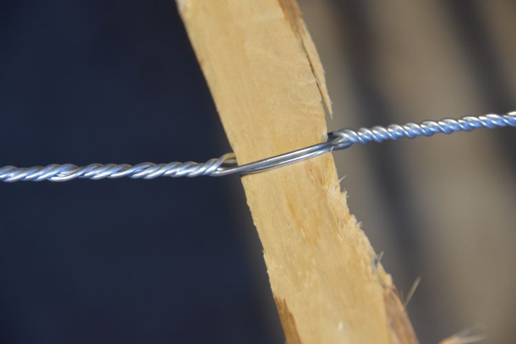 Latten worden tussen twee getordeerde gegalvaniseerde verbindingsdraden geklemd. Latten worden tussen twee getordeerde gegalvaniseerde verbindingsdraden geklemd.