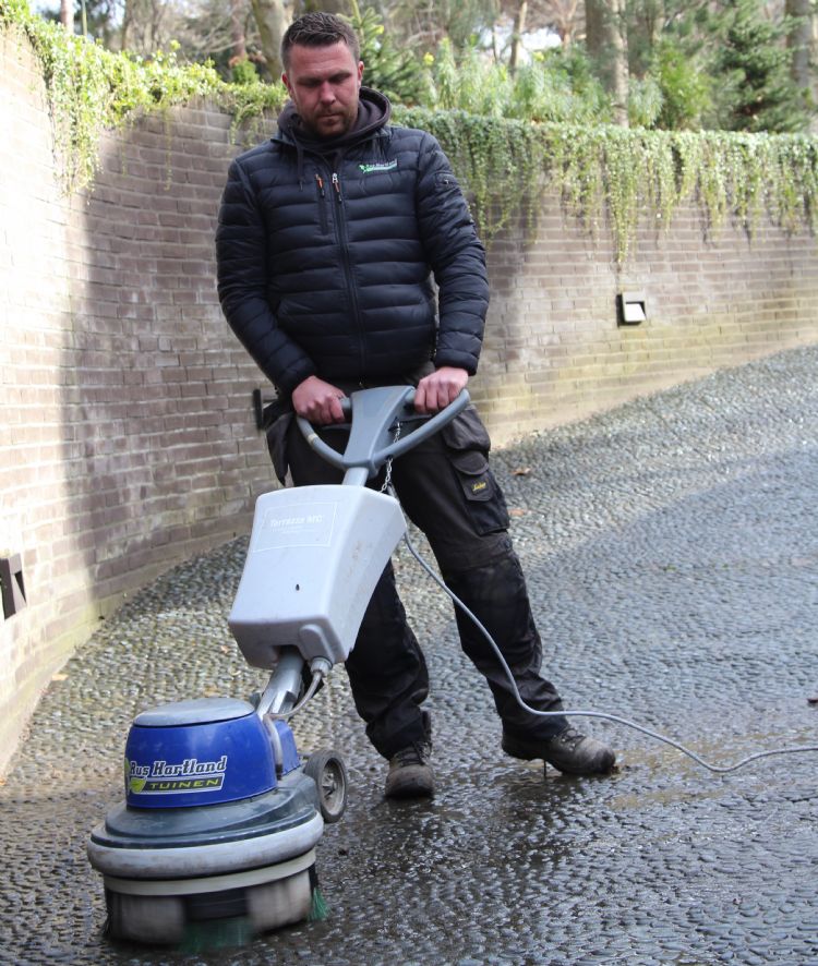 Met rustige halen reinigt Barry Rus Hartland de afrit naar een inpandige garage Met rustige halen reinigt Barry Rus Hartland de afrit naar een inpandige garage