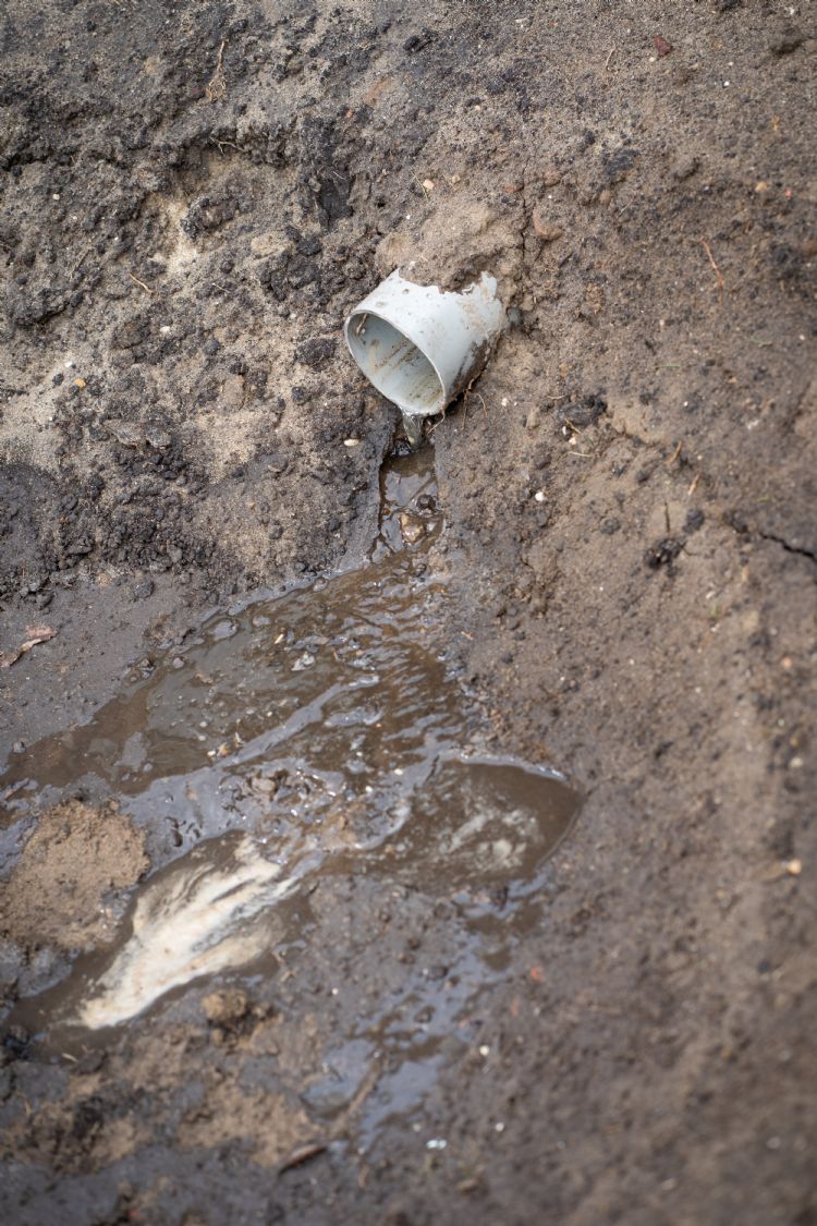 Een drainagebuis leidt het regenwater naar de vijver Een drainagebuis leidt het regenwater naar de vijver