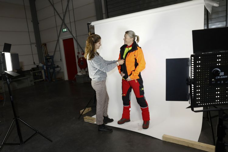 Redacteur Linde Kruese helpt Joey Wykret met haar regenjas.