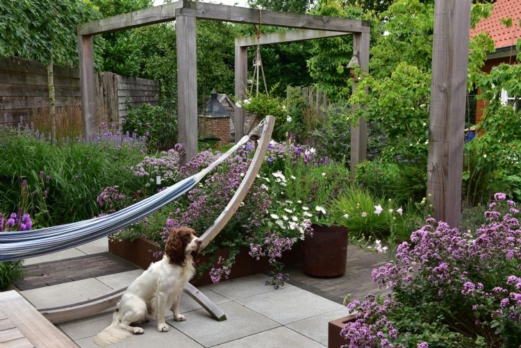 De tuin heeft verrassende hoekjes en doorkijkjes, door een diversiteit van materialen wordt dit extra versterkt.